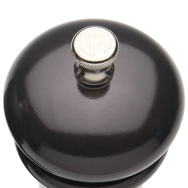 A black pepper mill with a silver knob.