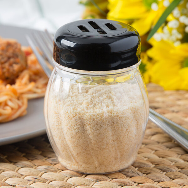 A Tablecraft black plastic slotted shaker top with white powder in it.