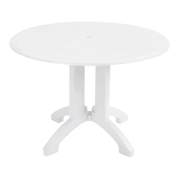 A Grosfillex white round table with white legs.