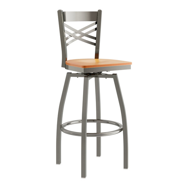 A Lancaster Table & Seating metal bar stool with a cherry wood seat.