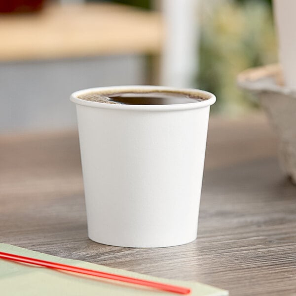 A Choice white poly paper hot cup on a table.