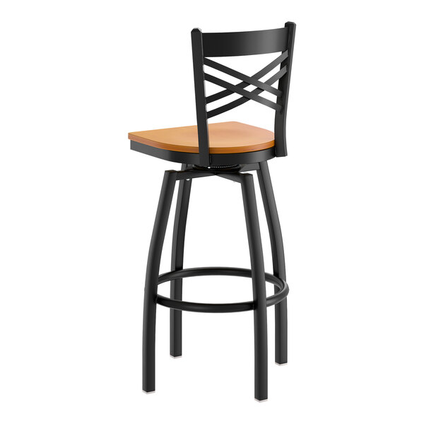A black metal swivel bar stool with a cross back design and a cherry wood seat.