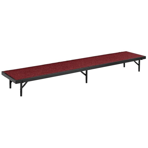 A long rectangular stage riser with red carpet.