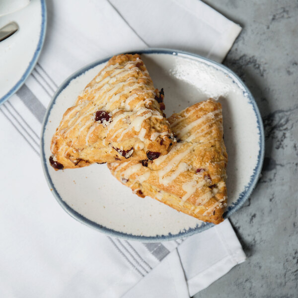 A rectangular porcelain plate with two scones on it.