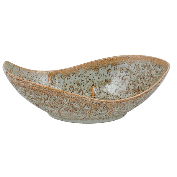 A close-up of a 10 Strawberry Street Tiger Eye porcelain canoe bowl with a speckled brown and white surface.