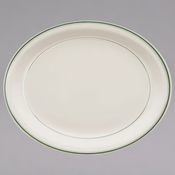 An ivory china oval platter with a green band.