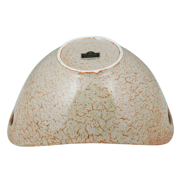 A white porcelain bowl with a tiger eye pattern and cut-out handles.