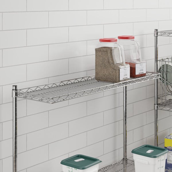 A Regency chrome wire cantilever shelf with containers on it.