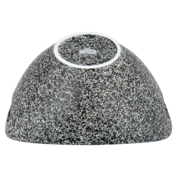 A white porcelain bowl with black granite accents and cut-out handles.