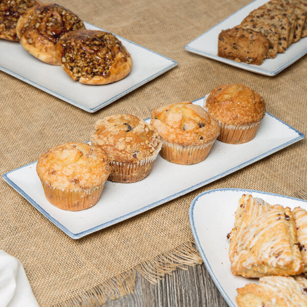 A rectangular porcelain platter with a variety of pastries on a table.