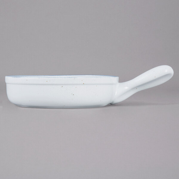 A white porcelain casserole bowl with a handle.