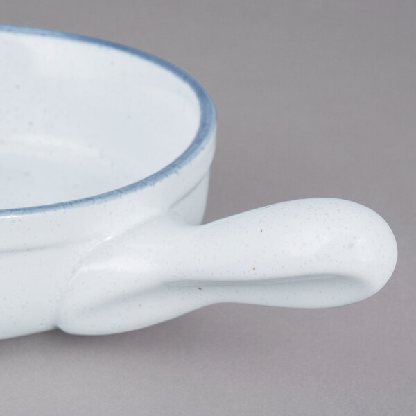 A close up of a white 10 Strawberry Street porcelain bowl with a handle.