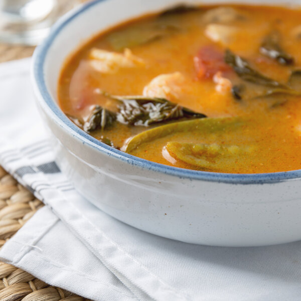 A 10 Strawberry Street Arctic Blue porcelain casserole bowl filled with soup and vegetables.