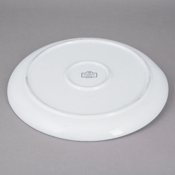 A white 10 Strawberry Street porcelain dinner plate with a circular design on it.