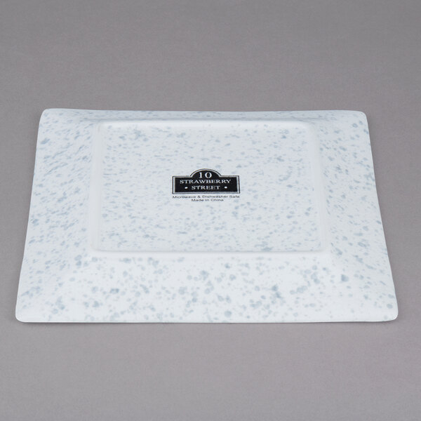 A white square porcelain plate with a black logo.