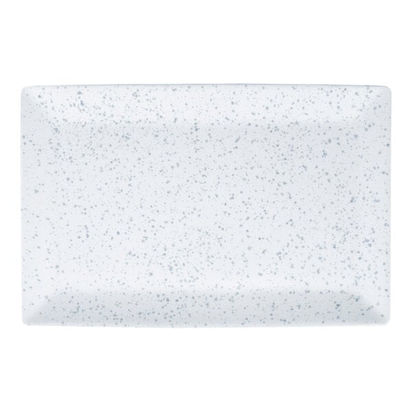 A rectangular white porcelain platter with a blue speckled pattern.