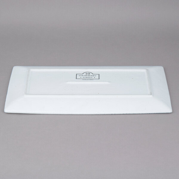 A white rectangular porcelain platter with a black logo on it.