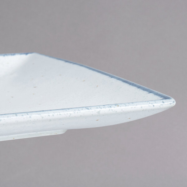 A close-up of a white rectangular porcelain platter with a small speckled design.