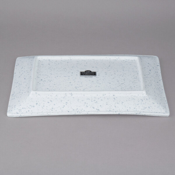 A white rectangular porcelain platter with black speckles.
