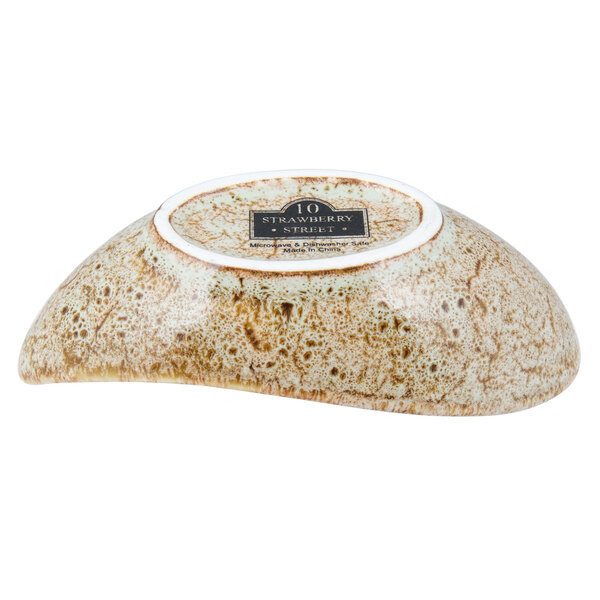 A white porcelain 10 Strawberry Street canoe-shaped bowl with a brown and white tiger eye design.