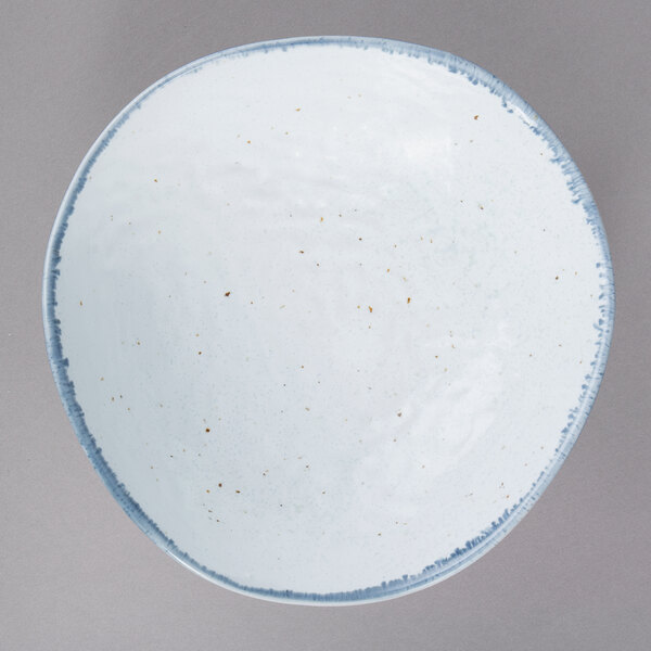 A white bowl with blue specks on it.