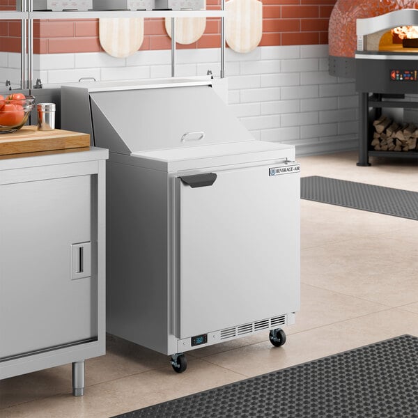 A stainless steel refrigerated sandwich prep table with a single door and a raised prep area.