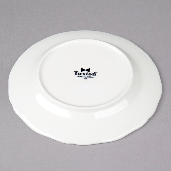 A white Tuxton Charleston bread and butter plate with a black logo.