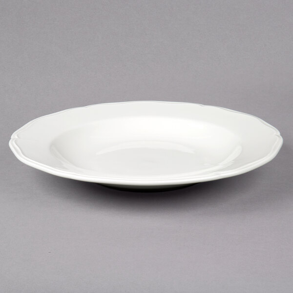 A Tuxton white china pasta bowl with a scalloped rim.