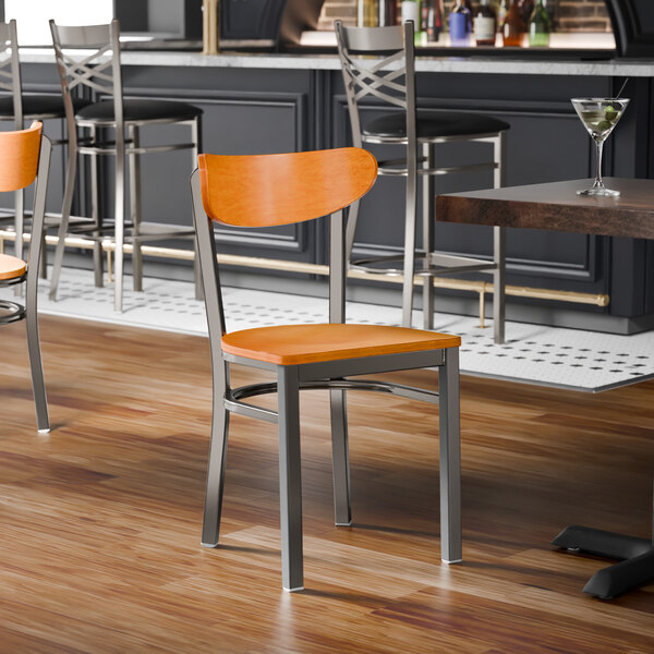 A metal chair with a cherry wood seat and backrest, featuring a clear coat finish.