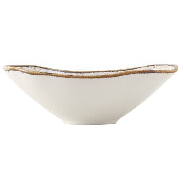 A close-up of a white Tuxton Capistrano bowl with a brown rim.
