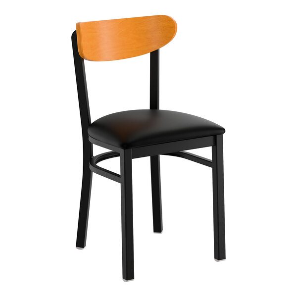 A black metal chair with a black vinyl seat and a cherry wood backrest.