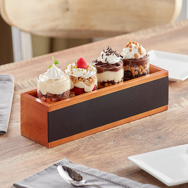 An Acopa flight crate with Barbary tasting glasses holding desserts on a wooden table.