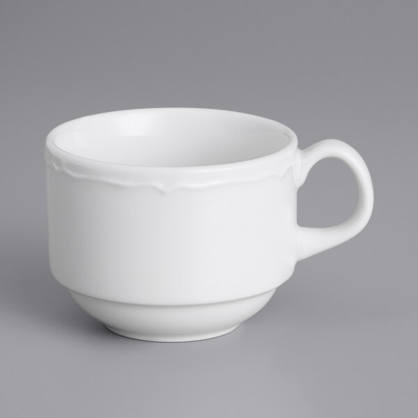 A white Tuxton China cup with a scalloped edge and handle.