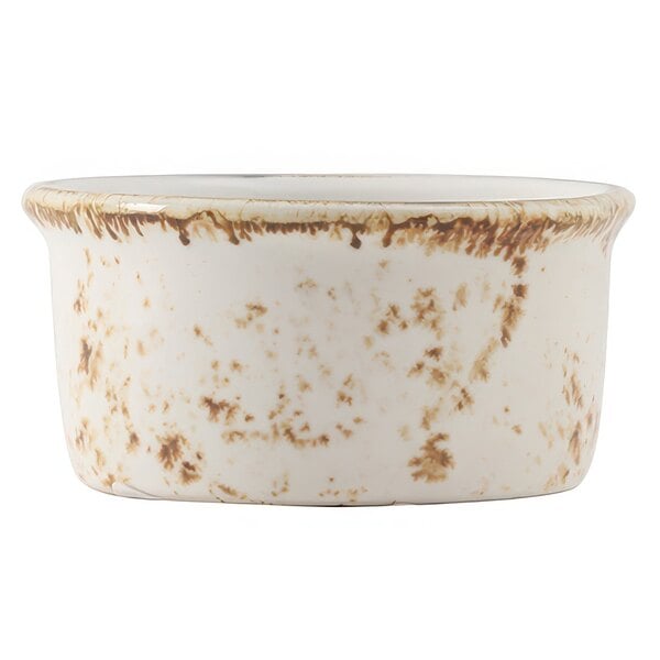 A white ceramic Tuxton ramekin with brown speckles.