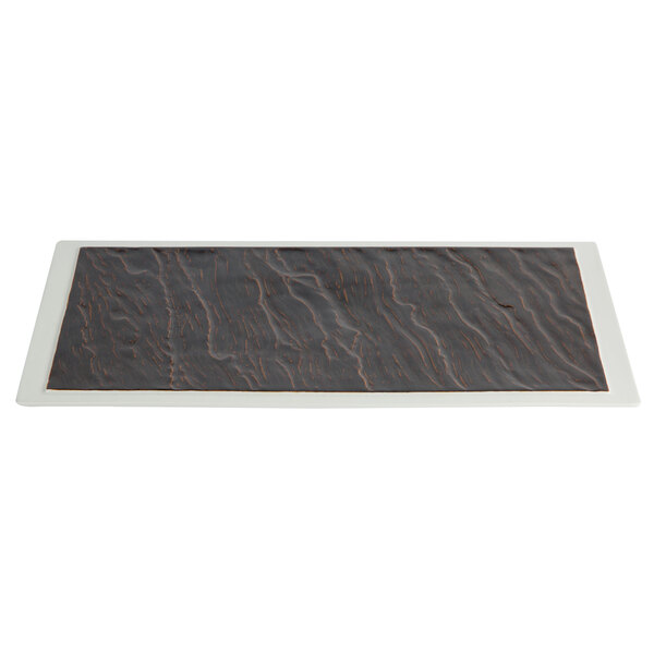 A rectangular black and white china platter with a black and brown pattern.