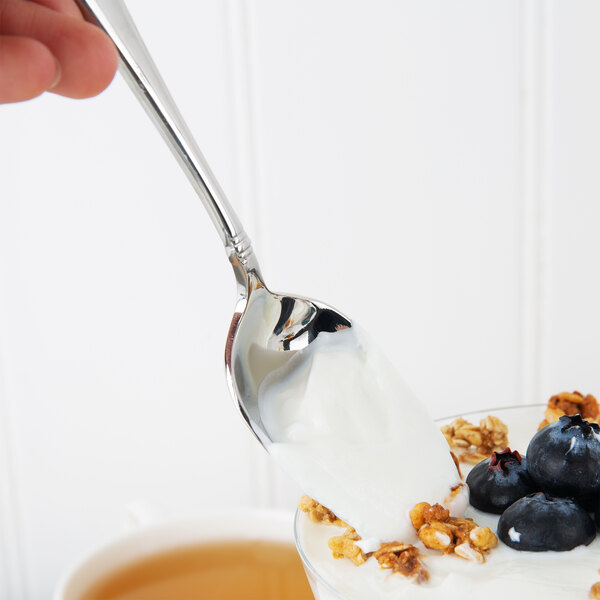 A Oneida stainless steel oval bowl spoon with yogurt, granola, and blueberries.