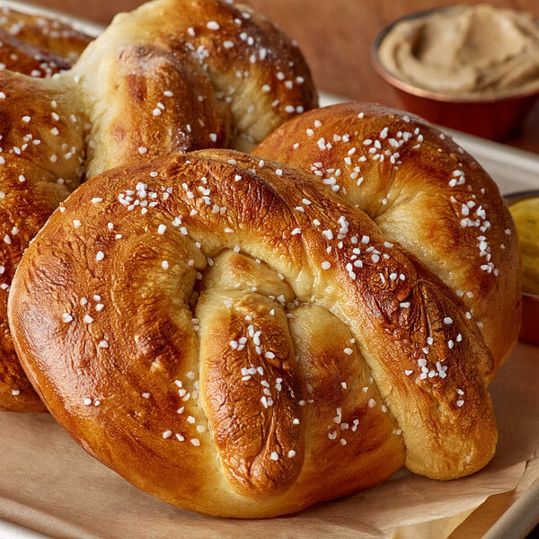 Two freshly baked pretzels on a white tray.