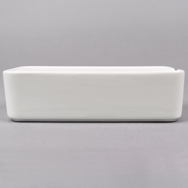 An Arcoroc white rectangular bowl on a white surface.