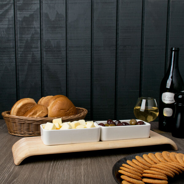 A group of Arcoroc white rectangular bowls filled with food on a table.