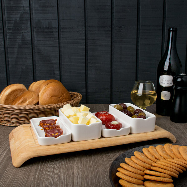 A white rectangular bowl filled with food on a wooden tray.