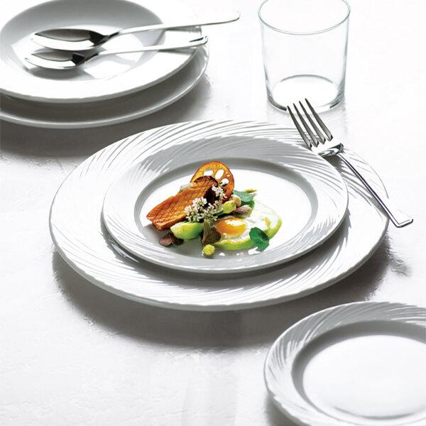 A white Arcoroc Candour porcelain banquet plate with a fork on it.