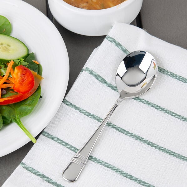 A Oneida Astragal stainless steel soup spoon on a napkin.