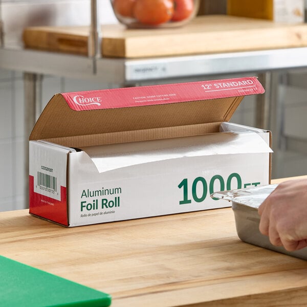 A large box of Choice 12-inch by 1000-foot standard aluminum foil roll for food service use.