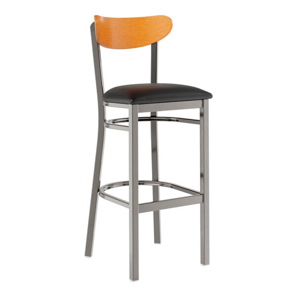 A Lancaster Table & Seating bar stool with a black vinyl seat and cherry wood back, metal frame, and clear coat finish.