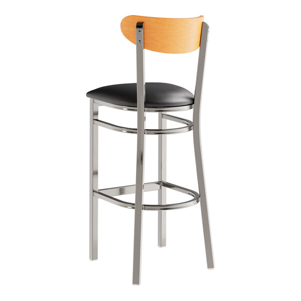 A Lancaster Table & Seating bar stool with a black vinyl seat and chrome legs.