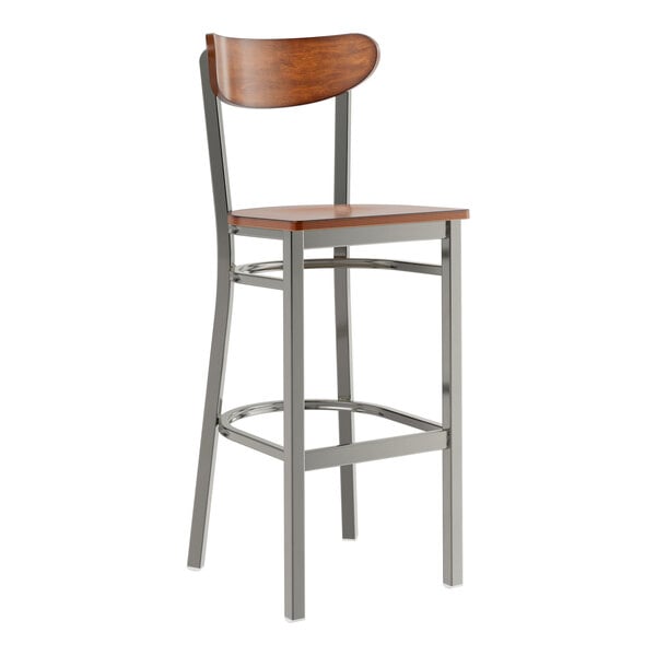 A Lancaster Table & Seating metal bar stool with a wooden seat and back.