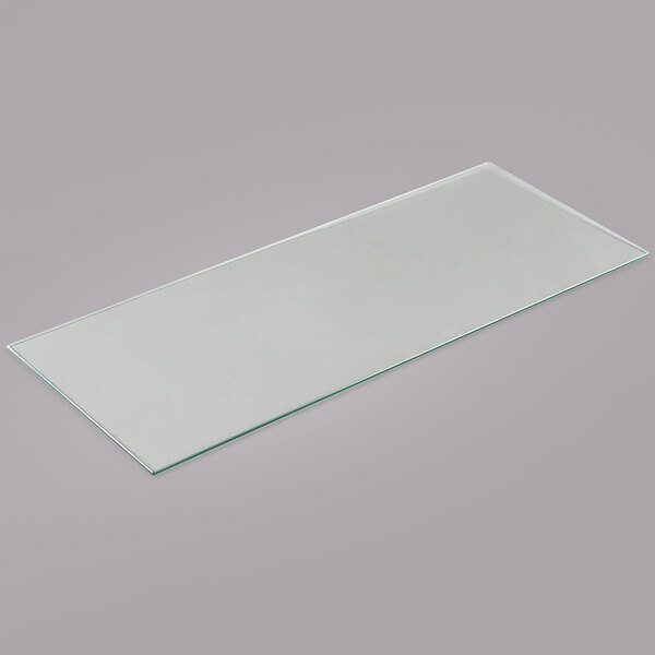 An Avantco glass shelf for bakery displays on a gray surface.