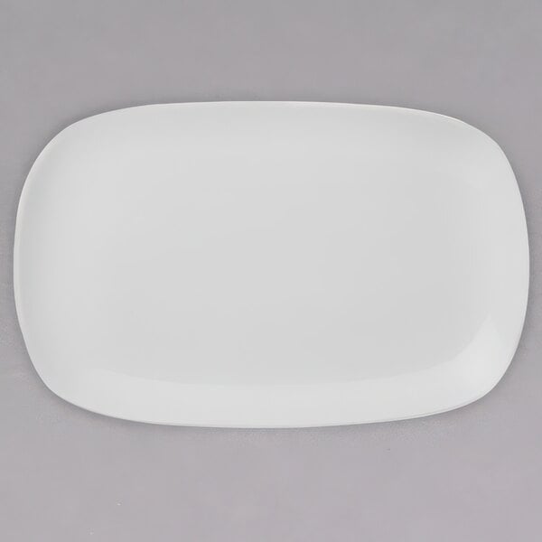 A white Arcoroc porcelain squared coupe platter on a gray surface.