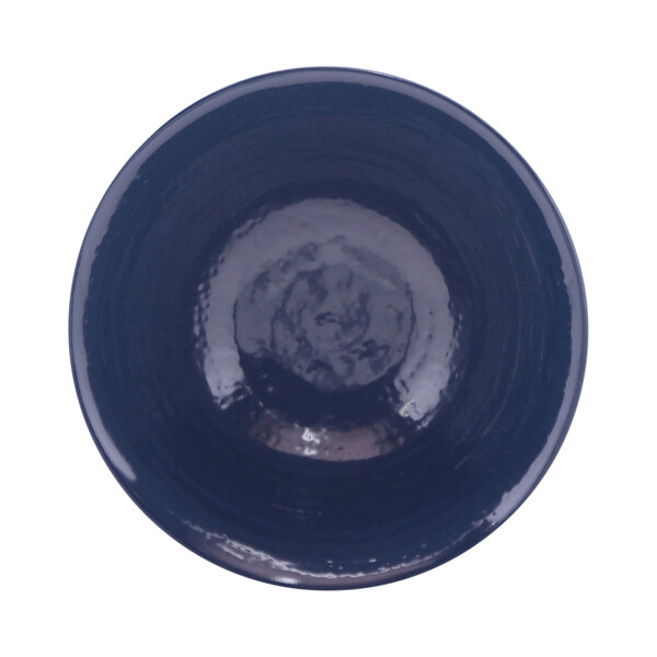 A round white melamine bowl with a dark blue rim.