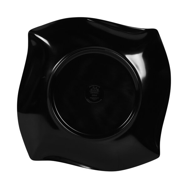 A black irregular square plate with a curved edge.